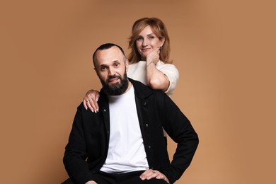 Photo of Portrait of lovely couple on brown background