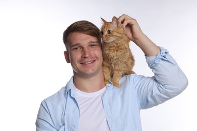 Photo of Man with cute ginger cat on white background