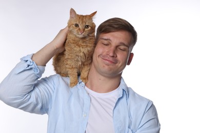 Photo of Man with cute ginger cat on white background