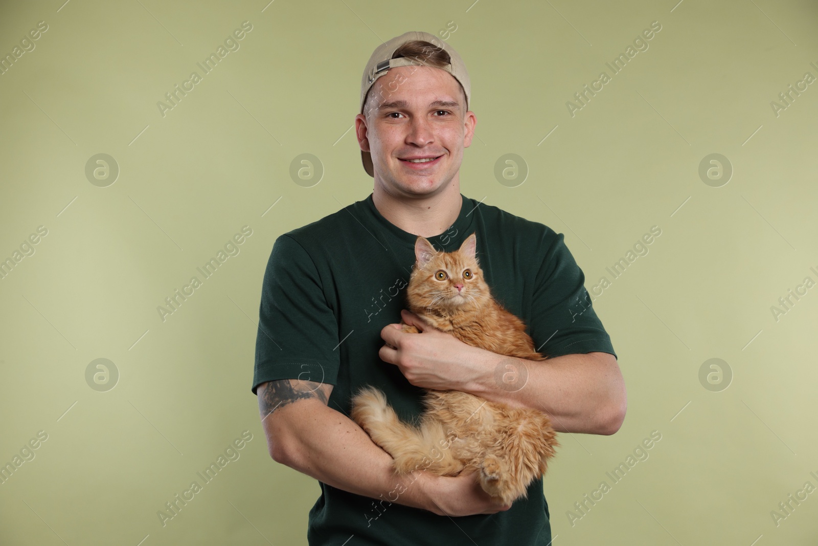 Man with cute ginger cat on light green background Photo of Man with cute ginger cat on light green background