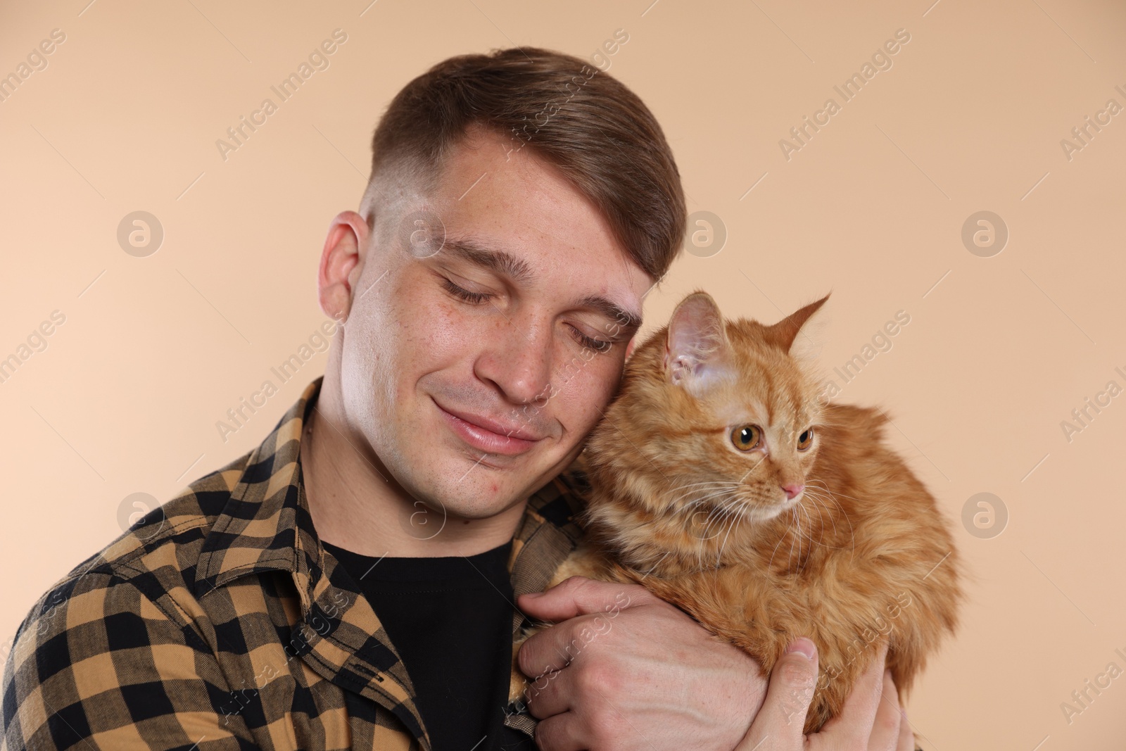 Man with cute ginger cat on beige background Photo of Man with cute ginger cat on beige background