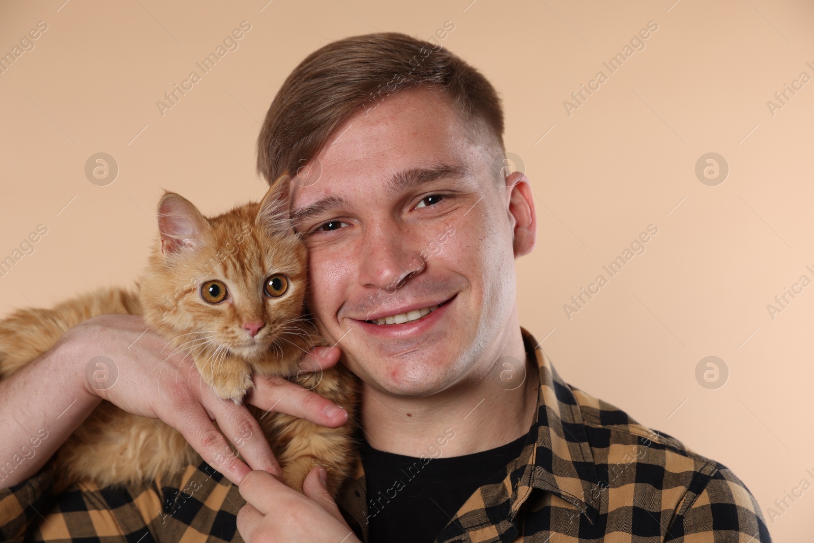 Man with cute ginger cat on beige background Photo of Man with cute ginger cat on beige background