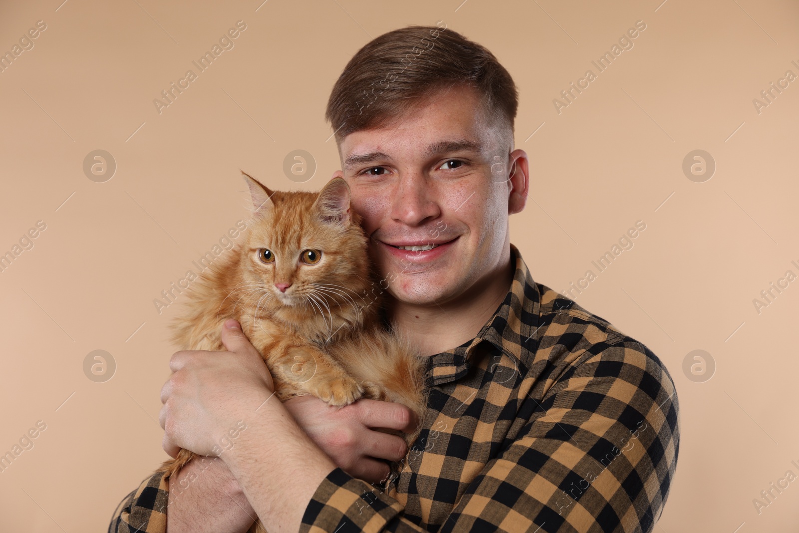 Man with cute ginger cat on beige background Photo of Man with cute ginger cat on beige background