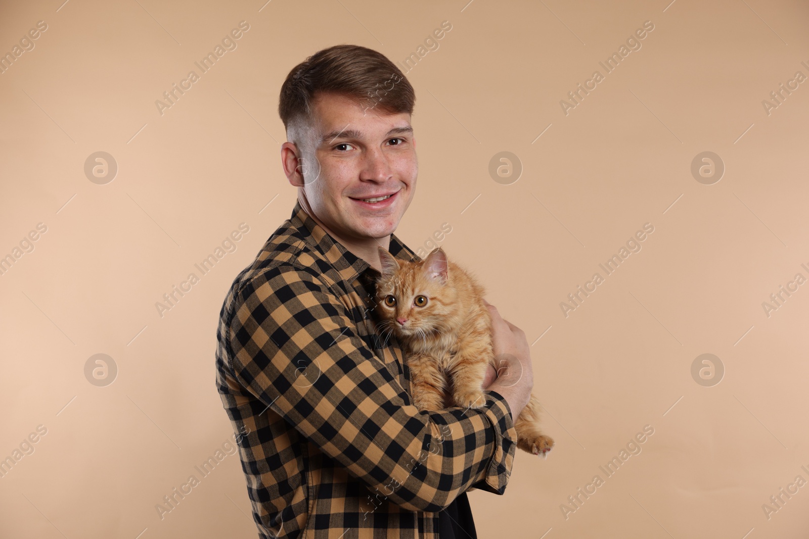 Man with cute ginger cat on beige background Photo of Man with cute ginger cat on beige background