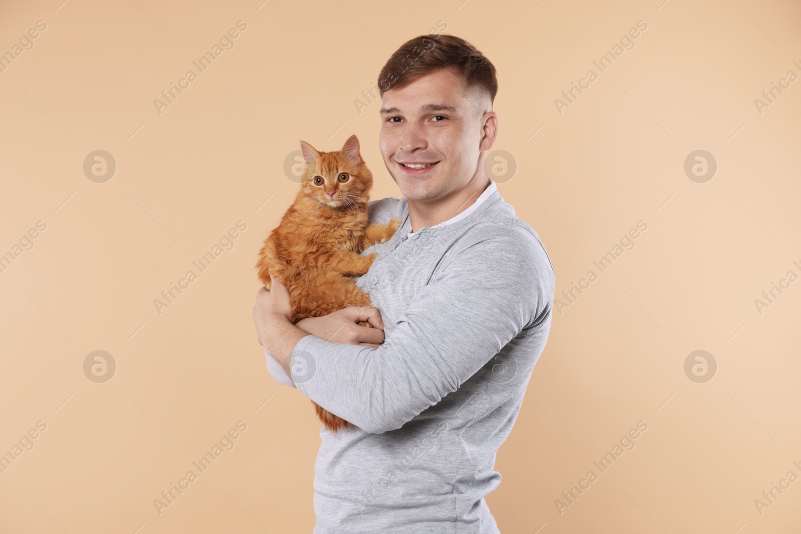 Man with cute ginger cat on beige background Photo of Man with cute ginger cat on beige background