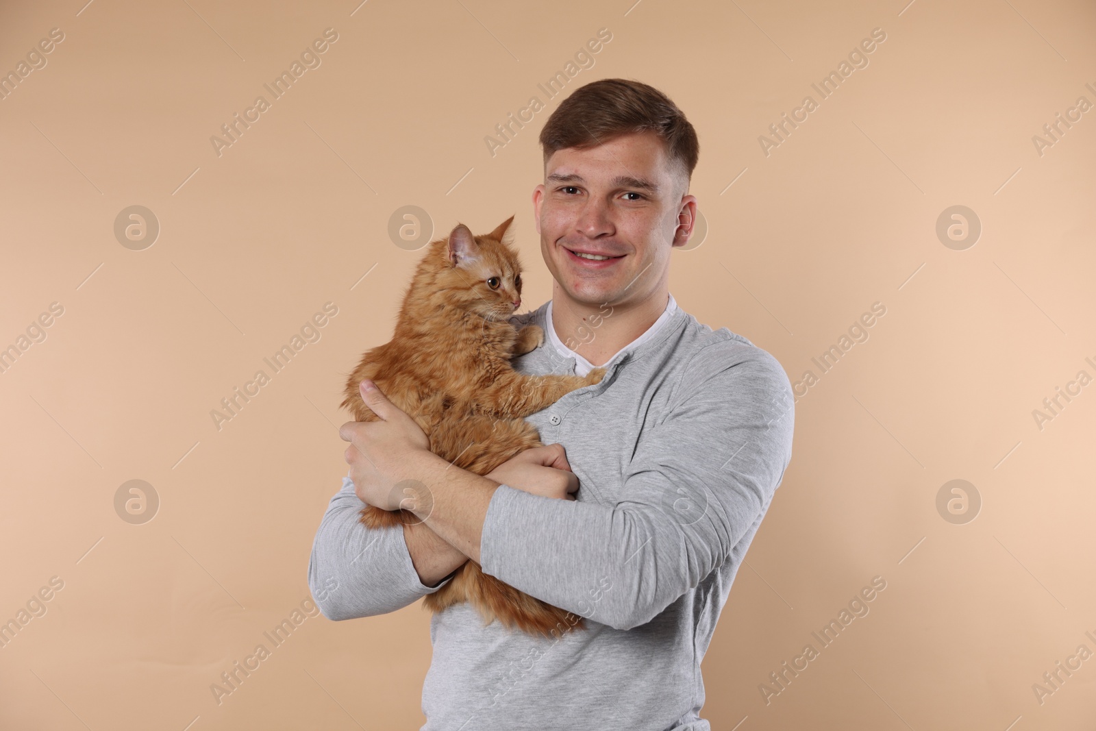 Man with cute ginger cat on beige background Photo of Man with cute ginger cat on beige background