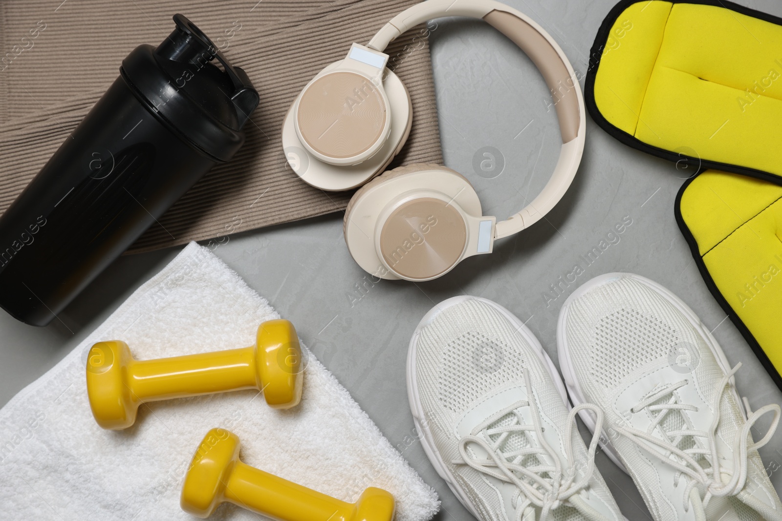 Sportswear, sneakers, headphones and other accessories on gray textured background, flat lay Photo of Sportswear, sneakers, headphones and other accessories on gray textured background, flat lay