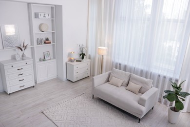 Photo of Stylish living room interior. Sofa, dresser, shelving unit and other furniture indoors, above view