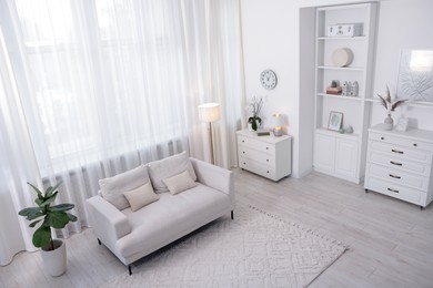 Photo of Stylish living room interior. Sofa, dresser, shelving unit and other furniture indoors, above view