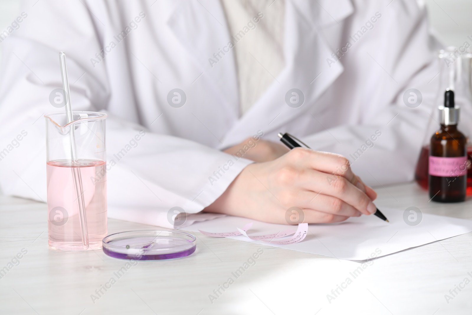 Professional perfumer developing luxury perfume at white wooden table in laboratory, closeup Photo of Professional perfumer developing luxury perfume at white wooden table in laboratory, closeup
