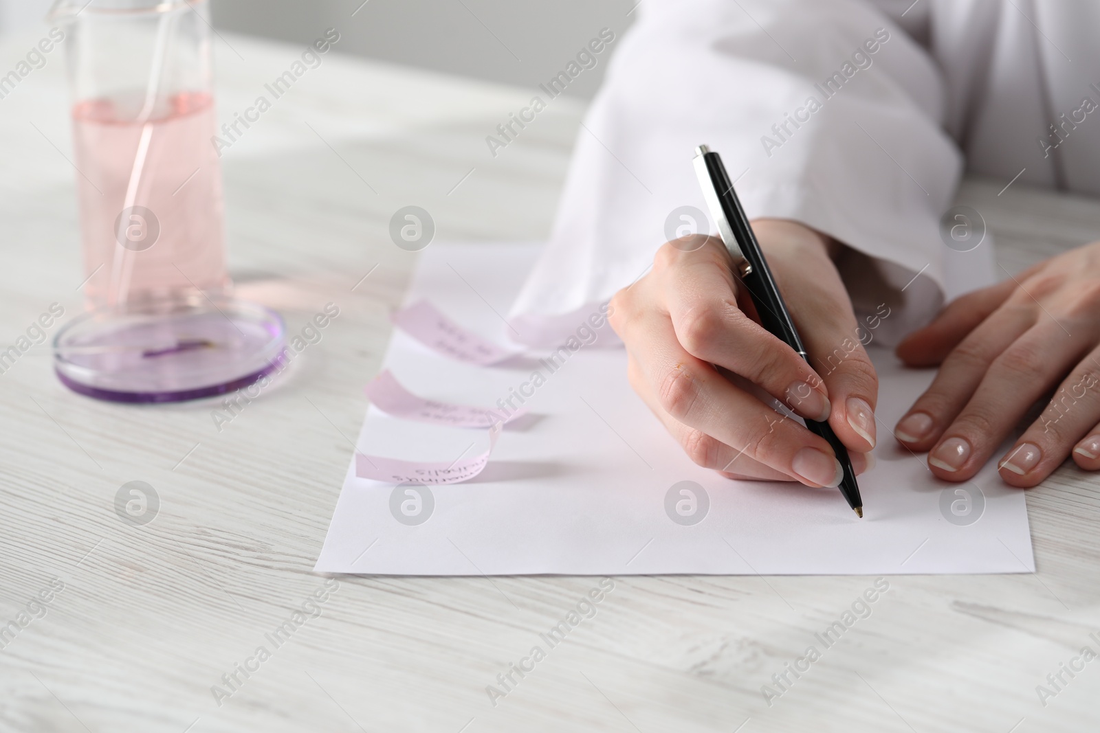 Professional perfumer developing luxury perfume at white wooden table in laboratory, closeup Photo of Professional perfumer developing luxury perfume at white wooden table in laboratory, closeup