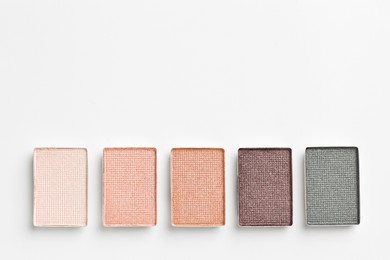 Photo of Beautiful eyeshadow refill pans on white background, flat lay. Space for text