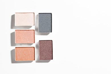 Photo of Beautiful eyeshadow refill pans on white background, flat lay. Space for text