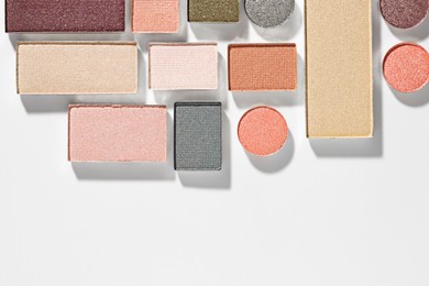 Photo of Beautiful eyeshadow refill pans on white background, flat lay. Space for text