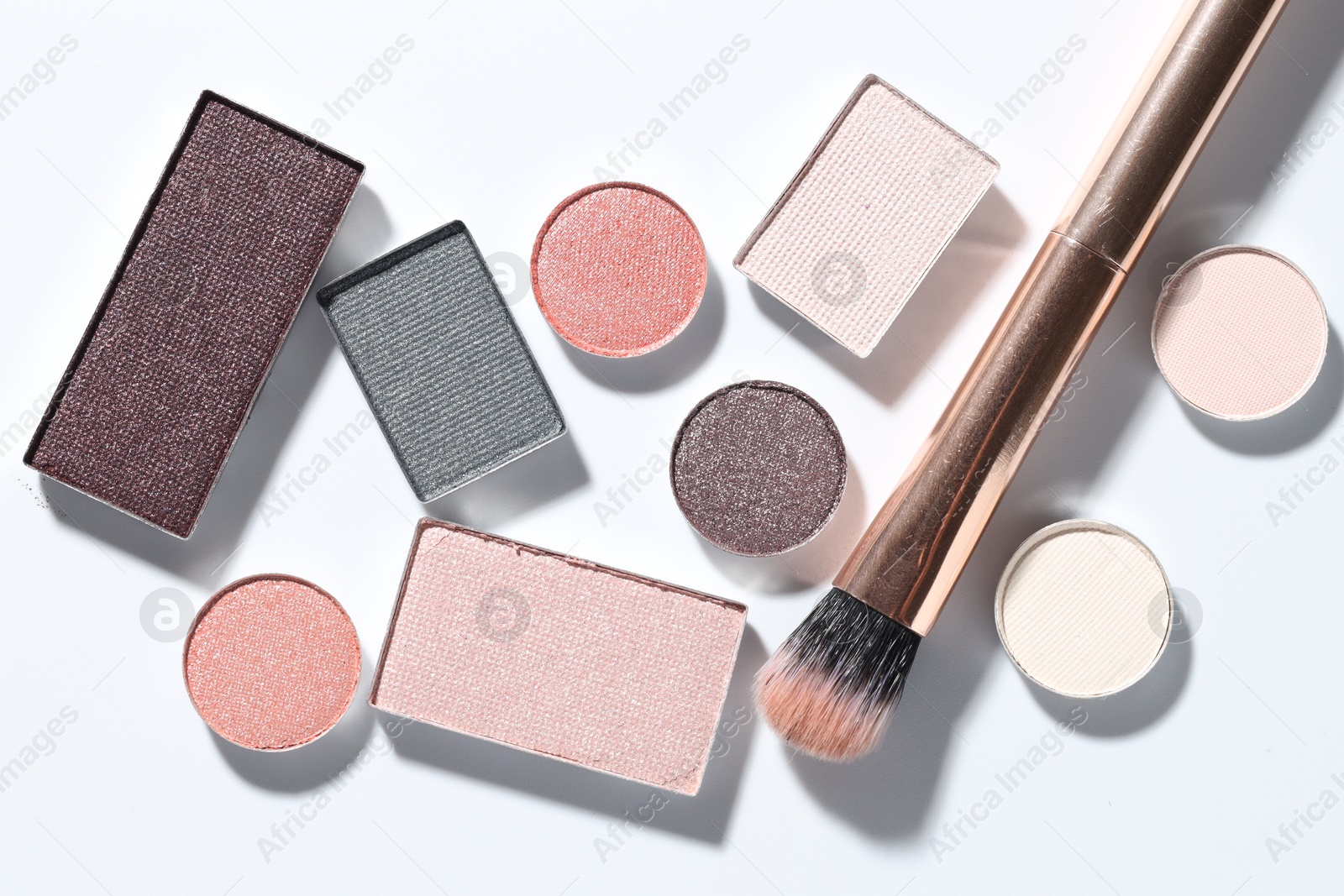 Beautiful eyeshadow refill pans and brush on white background, flat lay Photo of Beautiful eyeshadow refill pans and brush on white background, flat lay