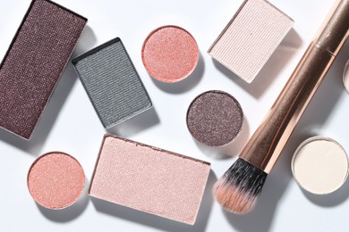 Photo of Beautiful eyeshadow refill pans and brush on white background, flat lay