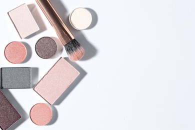Photo of Beautiful eyeshadow refill pans and brush on white background, flat lay. Space for text
