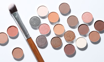 Photo of Beautiful eyeshadow refill pans and brush on white background, flat lay