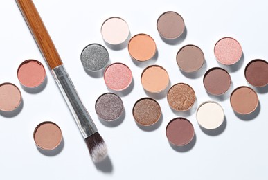 Photo of Beautiful eyeshadow refill pans and brush on white background, flat lay