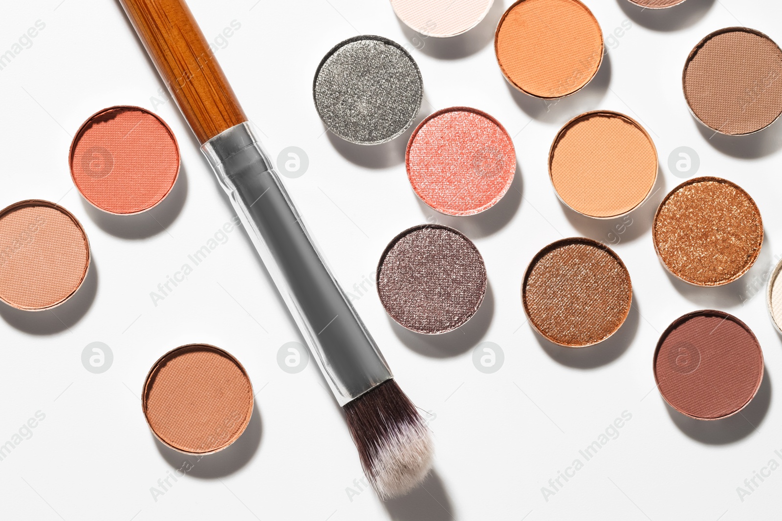 Beautiful eyeshadow refill pans and brush on white background, flat lay Photo of Beautiful eyeshadow refill pans and brush on white background, flat lay