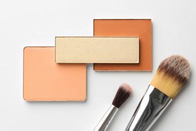 Photo of Beautiful eyeshadow refill pans and brushes on white background, flat lay