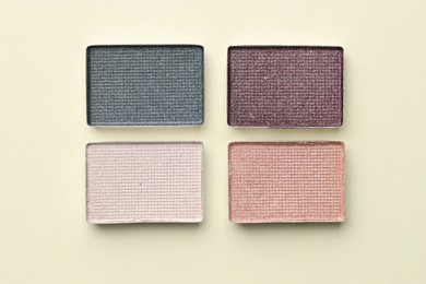 Photo of Beautiful eyeshadow refill pans on beige background, flat lay