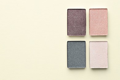 Photo of Beautiful eyeshadow refill pans on beige background, flat lay. Space for text