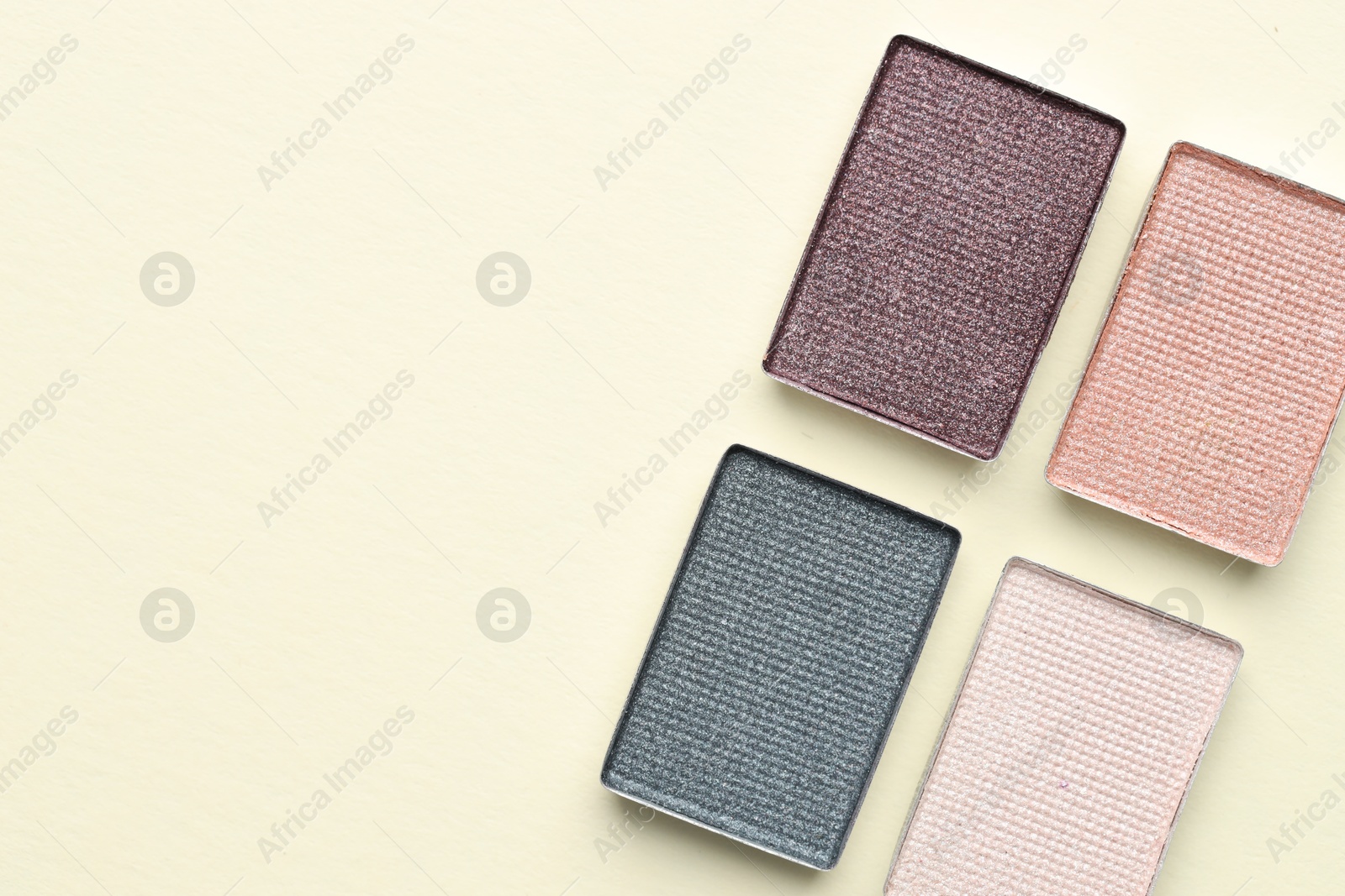 Beautiful eyeshadow refill pans on beige background, flat lay. Space for text Photo of Beautiful eyeshadow refill pans on beige background, flat lay. Space for text