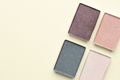 Photo of Beautiful eyeshadow refill pans on beige background, flat lay. Space for text