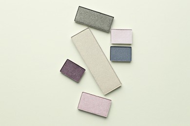 Photo of Beautiful eyeshadow refill pans on beige background, flat lay