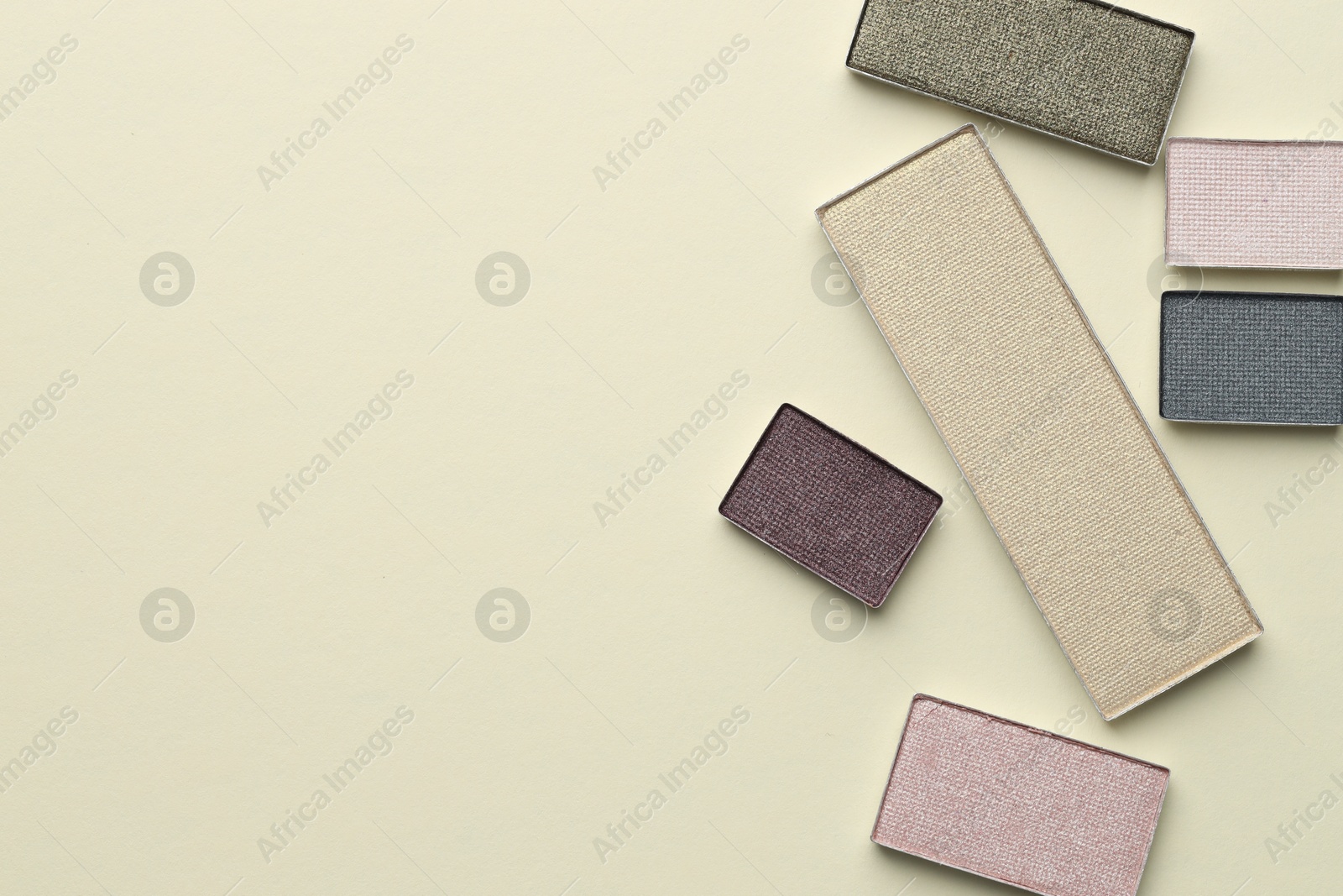 Beautiful eyeshadow refill pans on beige background, flat lay. Space for text Photo of Beautiful eyeshadow refill pans on beige background, flat lay. Space for text