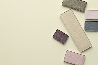 Photo of Beautiful eyeshadow refill pans on beige background, flat lay. Space for text