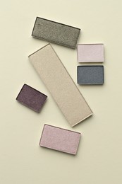 Photo of Beautiful eyeshadow refill pans on beige background, flat lay