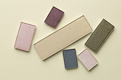 Photo of Beautiful eyeshadow refill pans on beige background, flat lay