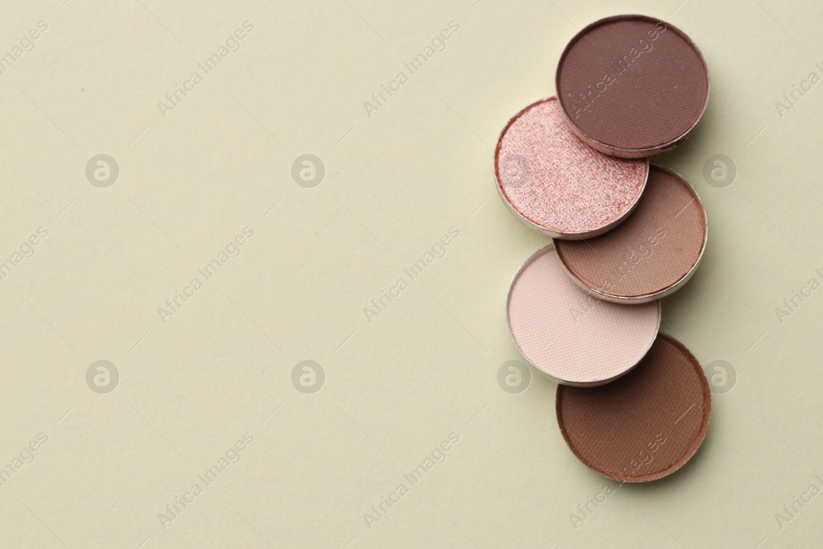 Beautiful eyeshadow refill pans on beige background, flat lay. Space for text Photo of Beautiful eyeshadow refill pans on beige background, flat lay. Space for text