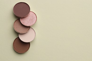 Photo of Beautiful eyeshadow refill pans on beige background, flat lay. Space for text