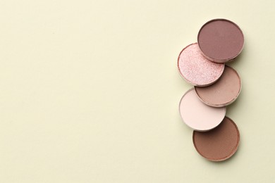 Photo of Beautiful eyeshadow refill pans on beige background, flat lay. Space for text