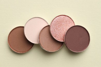 Photo of Beautiful eyeshadow refill pans on beige background, flat lay