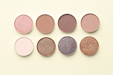Photo of Beautiful eyeshadow refill pans on beige background, flat lay
