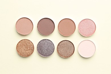 Photo of Beautiful eyeshadow refill pans on beige background, flat lay