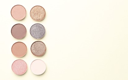 Photo of Beautiful eyeshadow refill pans on beige background, flat lay. Space for text