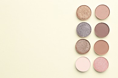 Photo of Beautiful eyeshadow refill pans on beige background, flat lay. Space for text