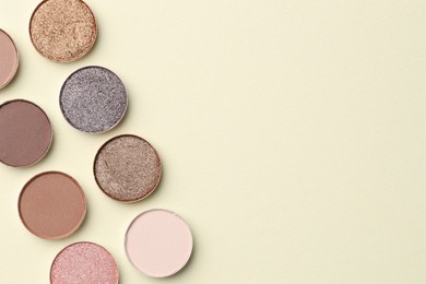 Photo of Beautiful eyeshadow refill pans on beige background, flat lay. Space for text