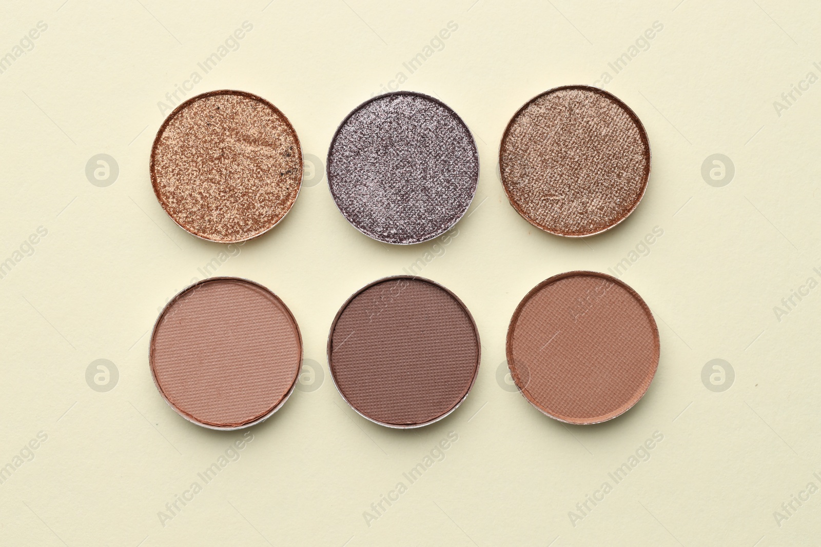 Beautiful eyeshadow refill pans on beige background, flat lay Photo of Beautiful eyeshadow refill pans on beige background, flat lay
