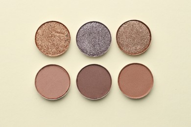 Photo of Beautiful eyeshadow refill pans on beige background, flat lay