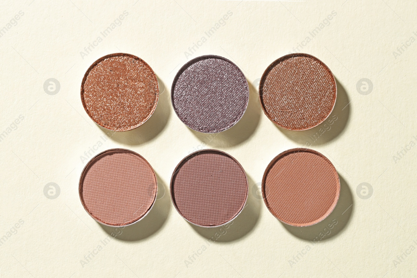Beautiful eyeshadow refill pans on beige background, flat lay Photo of Beautiful eyeshadow refill pans on beige background, flat lay