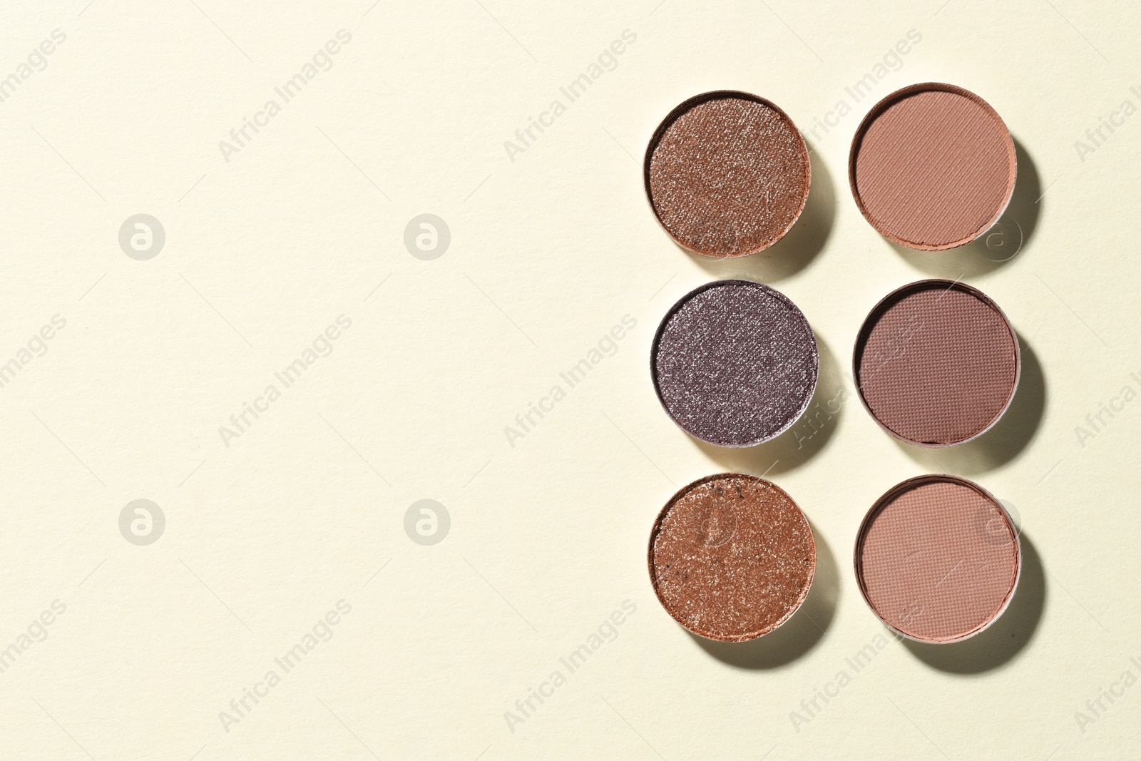 Beautiful eyeshadow refill pans on beige background, flat lay. Space for text Photo of Beautiful eyeshadow refill pans on beige background, flat lay. Space for text