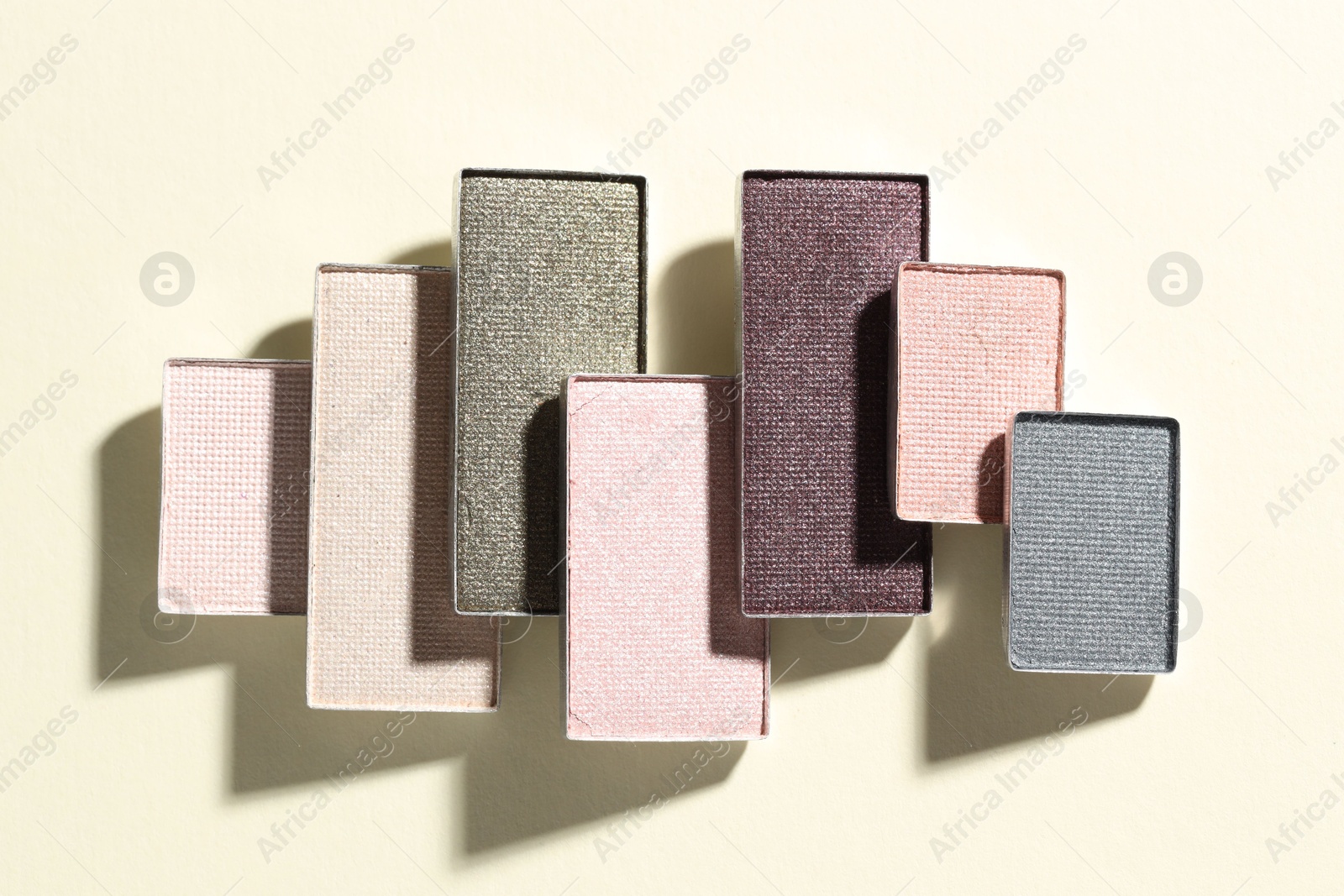 Beautiful eyeshadow refill pans on beige background, flat lay Photo of Beautiful eyeshadow refill pans on beige background, flat lay