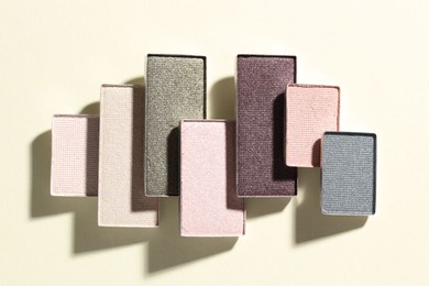 Photo of Beautiful eyeshadow refill pans on beige background, flat lay