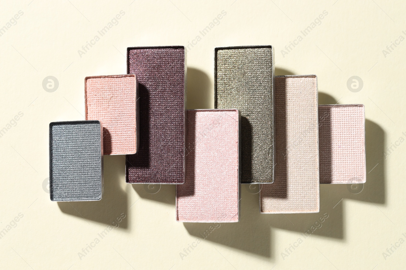 Beautiful eyeshadow refill pans on beige background, flat lay Photo of Beautiful eyeshadow refill pans on beige background, flat lay